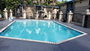 A rectangular swimming pool with clear blue water, surrounded by a tiled deck.