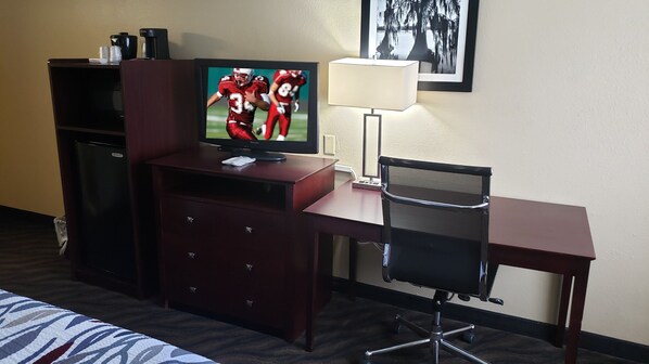 A hotel room with a TV, desk, chair, and a bed. - Red Roof Inn Port Allen West LSU Stadium (Port Allen)