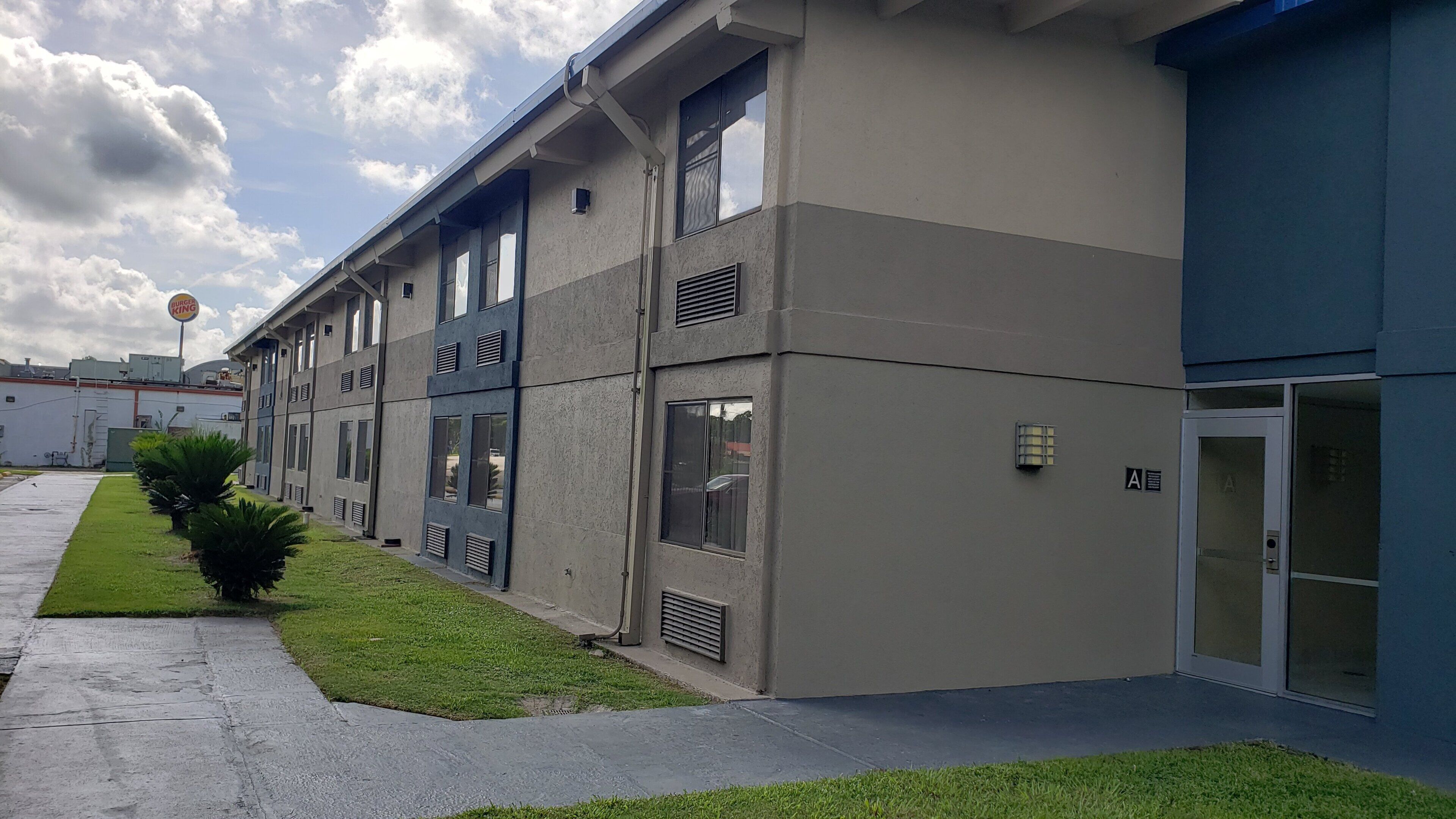 Un edificio de varios pisos con fachada plana, ventanas grandes y un cartel que indica Burger King.