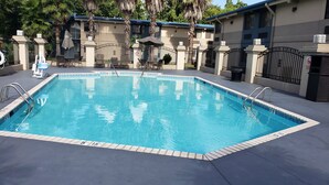 A rectangular swimming pool with clear blue water, surrounded by a tiled deck. - Red Roof Inn Port Allen West LSU Stadium (Port Allen)