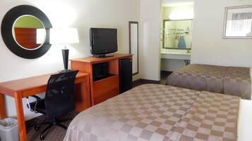 Una habitación de hotel con escritorio, silla, televisión y dos camas.