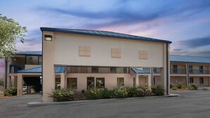 A two-story motel with a flat roof and a covered parking area.