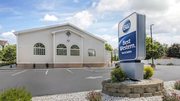 A Best Western Inn & Suites with a white exterior, large arched windows, and a signboard.
