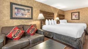 A hotel room with a large bed, a sofa, two lamps, and framed pictures on the walls. - Best Western Plus Inn of Santa Fe (Santa Fe)