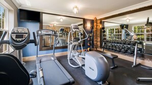 A gym with treadmills, ellipticals, and a bench.