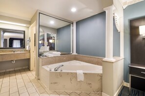 A modern bathroom with a large bathtub, a vanity with a mirror, and a separate shower area. - Best Western Inn (Winchester)
