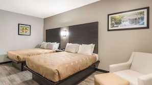 A hotel room with two beds, a sofa, and a small table. - Quality Inn & Suites  Fort Worth - Fossil Creek (Fort Worth)