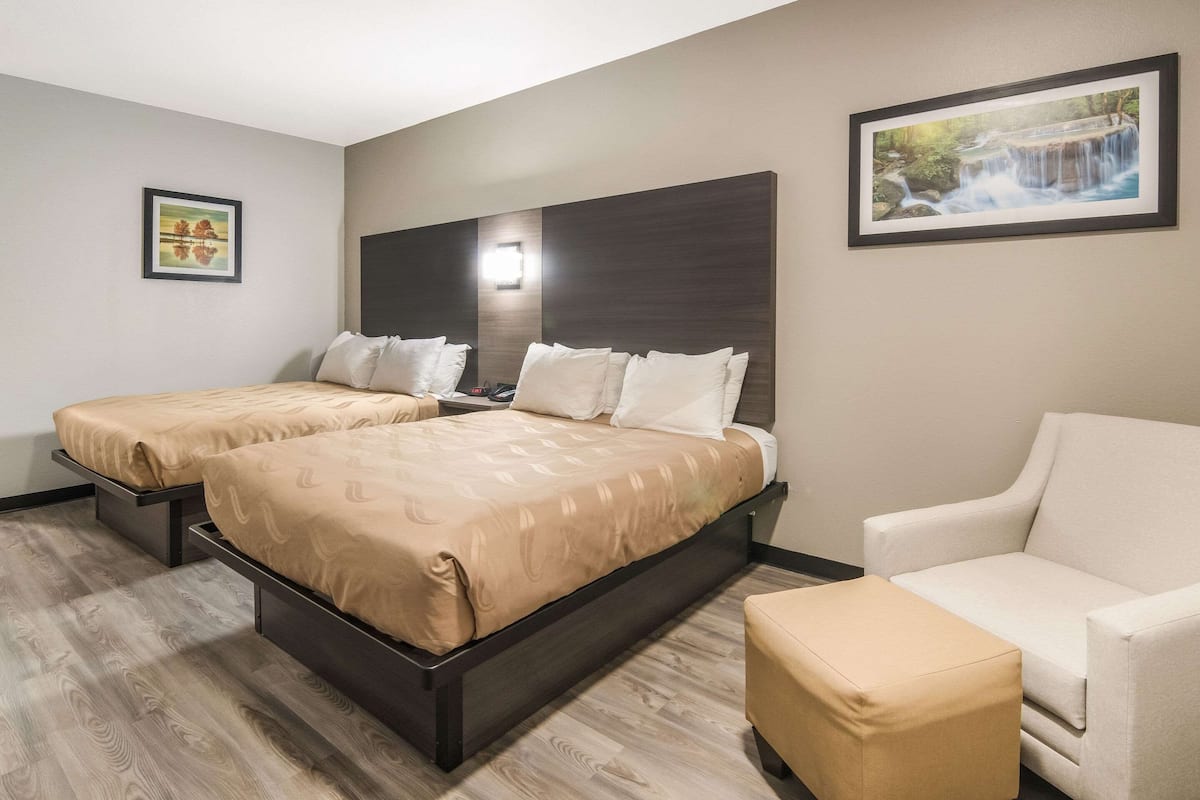 Ein Hotelzimmer mit zwei Betten, einem Sofa und einem kleinen Tisch.