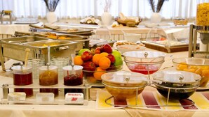 Un buffet proposant une variété d’aliments et d’accompagnements, notamment des fruits, des confitures et des sauces.