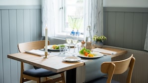 Una mesa de comedor con platos, vasos y una vela.