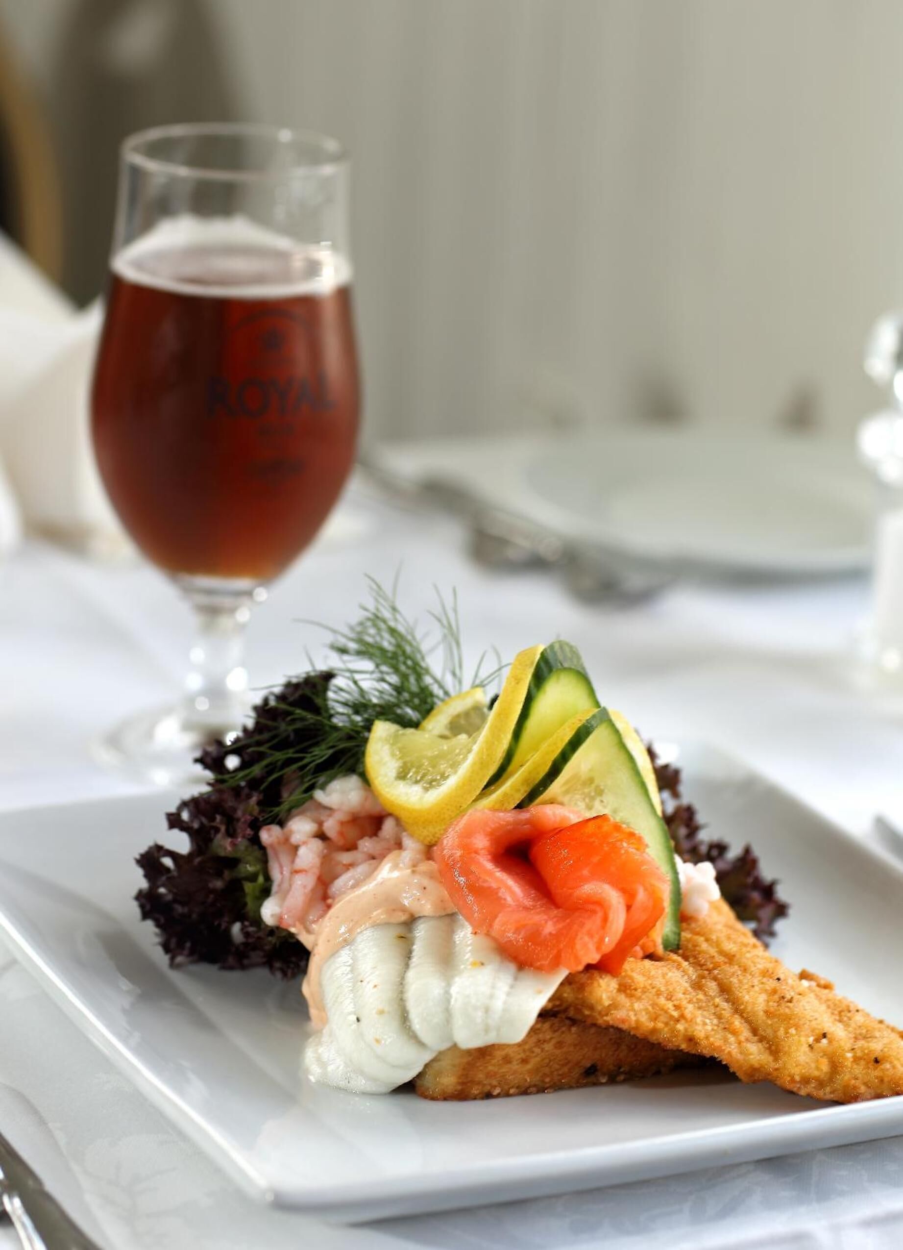 A seafood dish with a glass of red wine on a white plate.
