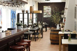 A restaurant interior with a bar area, dining tables, chairs, and a variety of decorative items. - Aars Hotel (Aars)