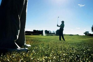 A golf course with a clear sky and a golfer in the distance. - Aars Hotel (Aars)