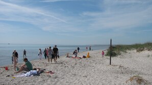 A beach with people sunbathing and walking. - Dronninglund Hotel (Dronninglund)