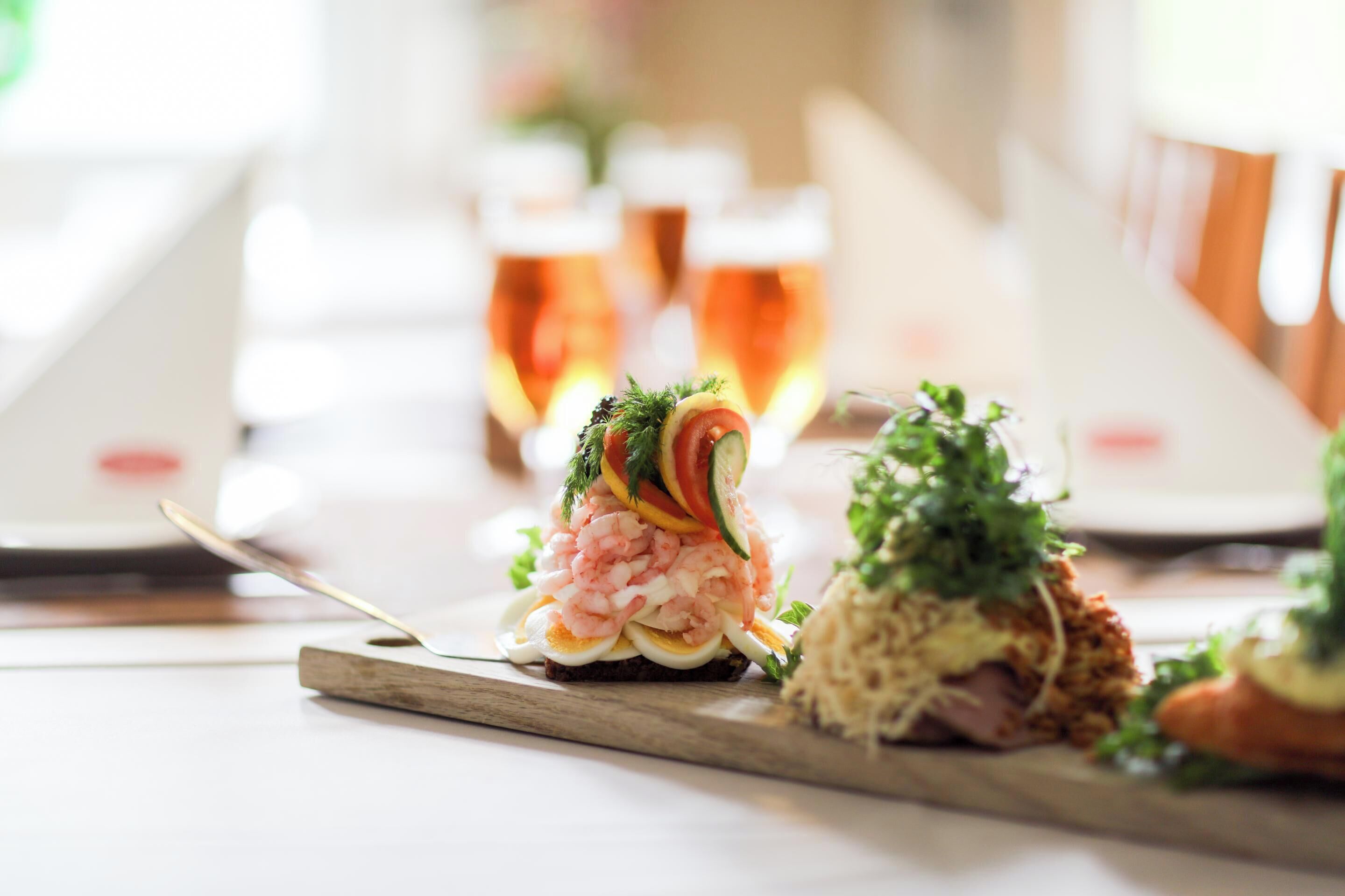 Une table à manger avec différents plats et des verres de bière.