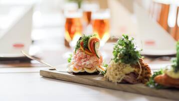 A dining table with various dishes and glasses of beer.