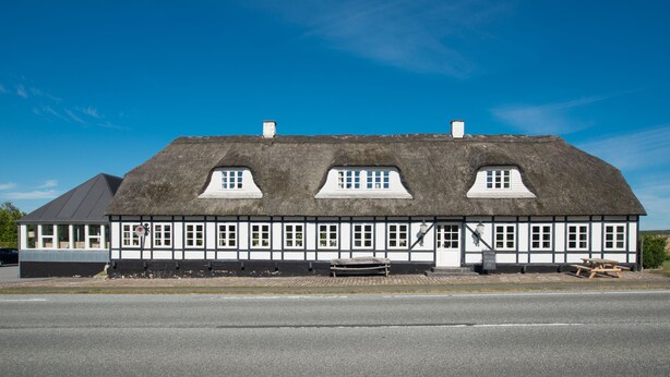 A traditional building with a thatched roof, multiple windows, and a small porch area. - Hotel Årslev Kro (Aarhus)