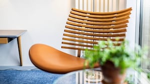 A modern interior with a wooden chair and a brown sofa. - Strandhotellet (Ebeltoft)