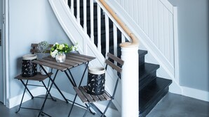 A staircase with white railings and a wooden handrail, leading to a landing with a small table and chairs. - Refborg Hotel & Spiseri (Billund)