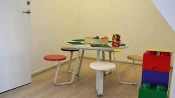 Cozy room with a simple layout, featuring a round table, a small table, and a comfortable stool.
