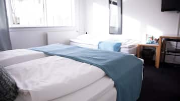 Una habitación de hotel con dos camas, un escritorio, una silla y un televisor.