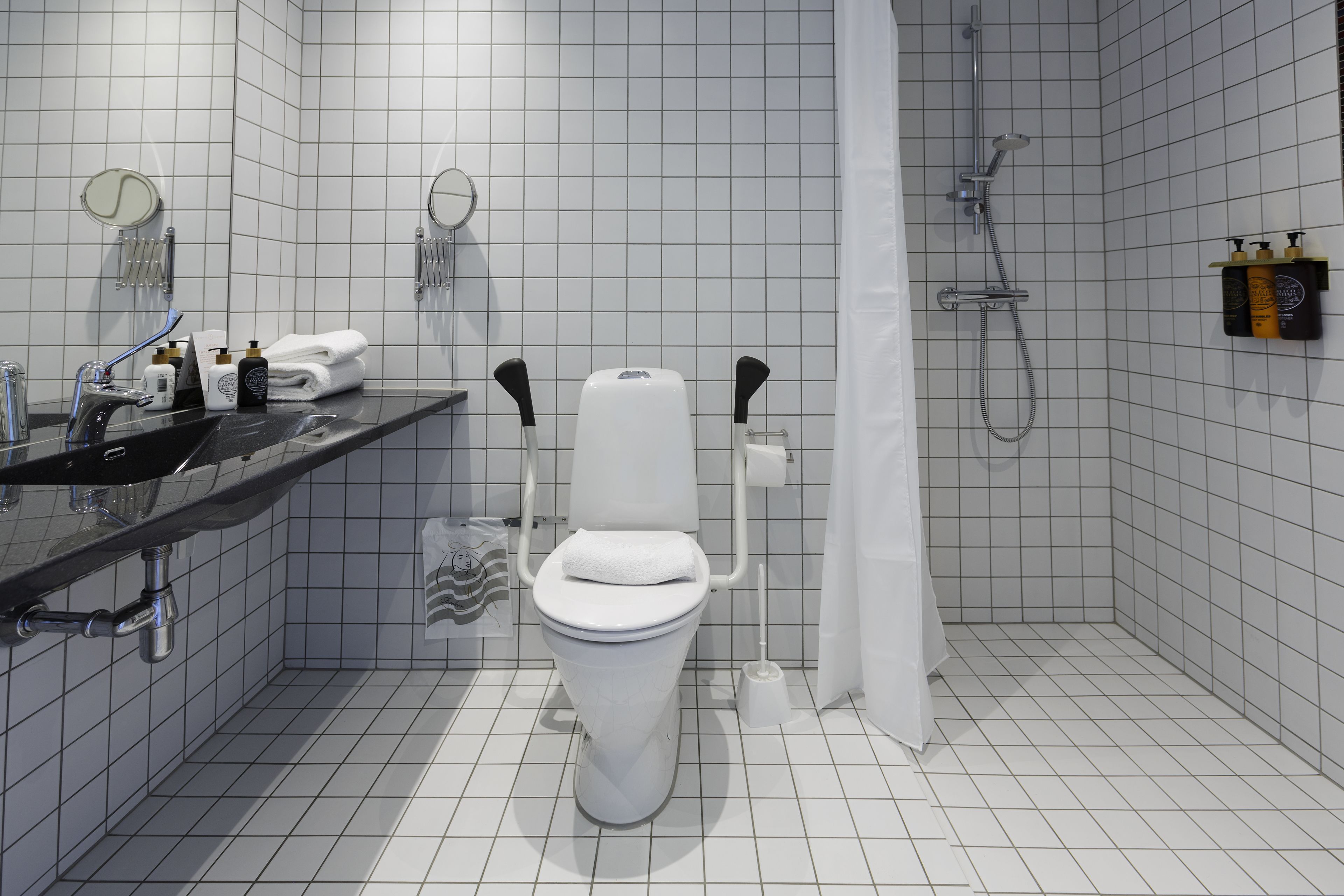 Ein modernes Badezimmer mit Toilette, Waschbecken und Dusche.