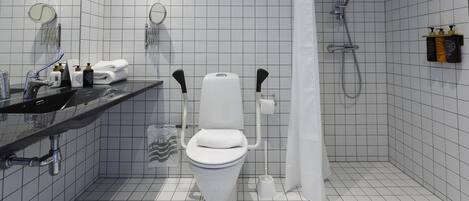 Un baño moderno con inodoro, lavamanos y ducha.