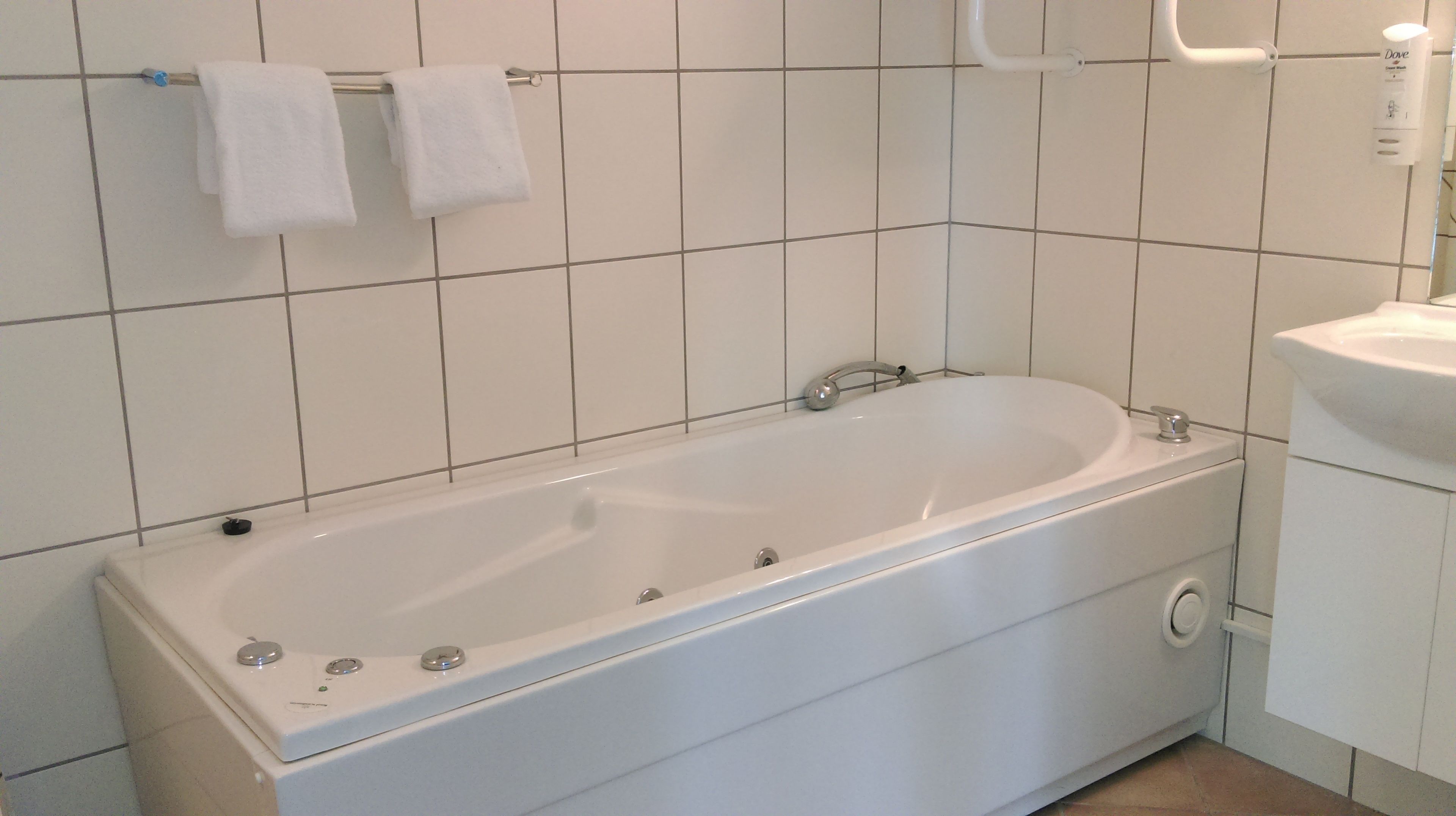 Un baño con una bañera blanca, un inodoro y un lavabo.