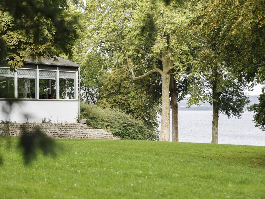 A gazebo with a stone wall and a view of the water.