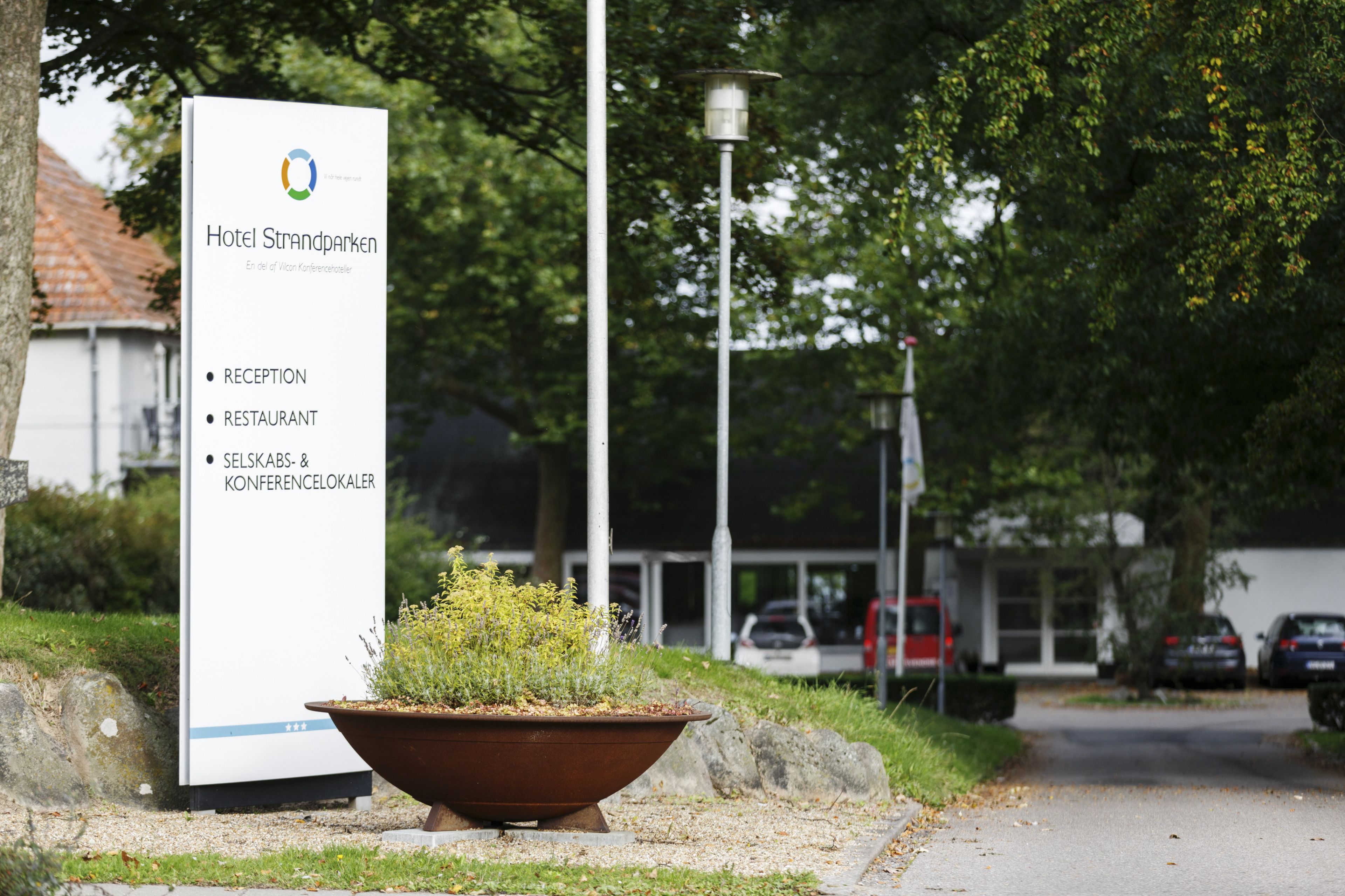 A sign for Hotel Strandparken with amenities listed: Reception, Restaurant, Self-service, and Conference rooms.
