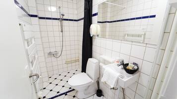Un baño pequeño con inodoro, lavabo y ducha.