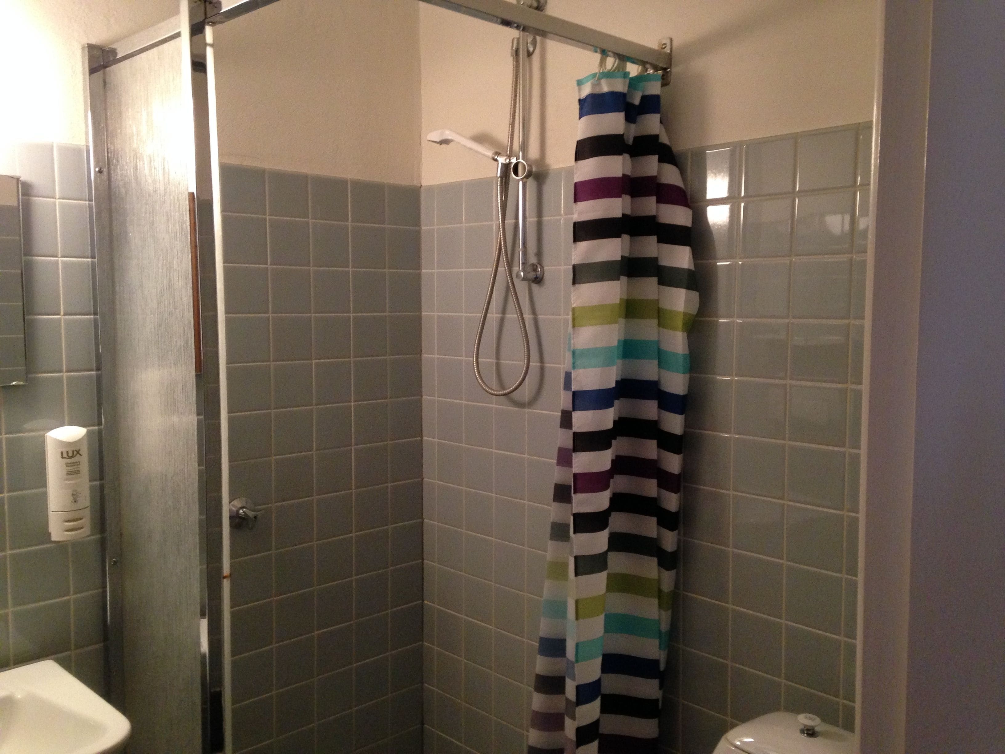 Un baño con ducha, inodoro y lavamanos.