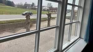 A view through a window with a wooden post and a road with a speed limit sign. - Blommenslyst Kro (Blommenslyst)
