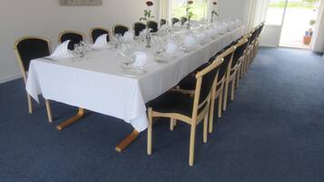 A long dining table set for a formal event with chairs and glassware.