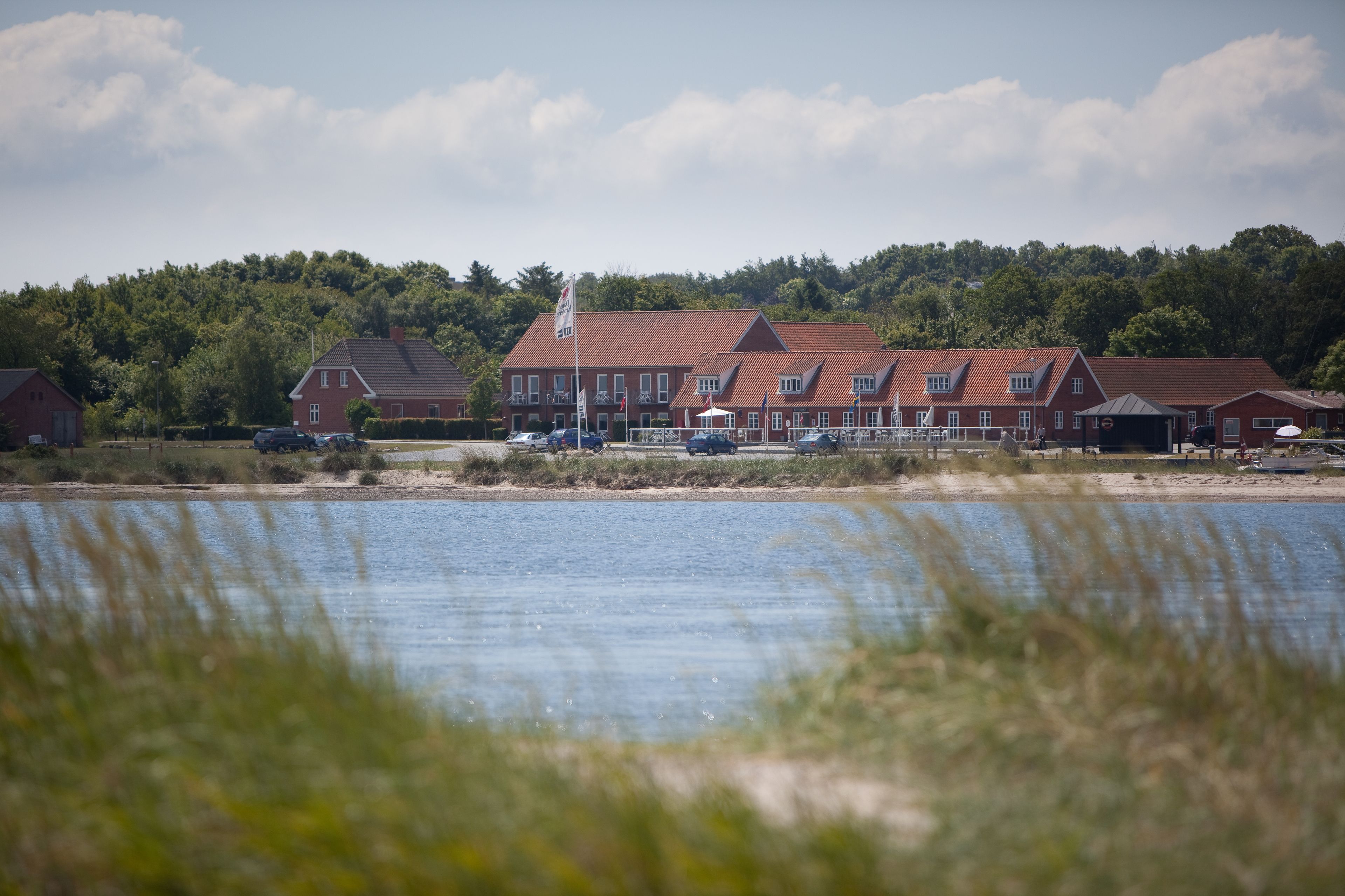 A large red building with multiple sections, situated near a body of water.