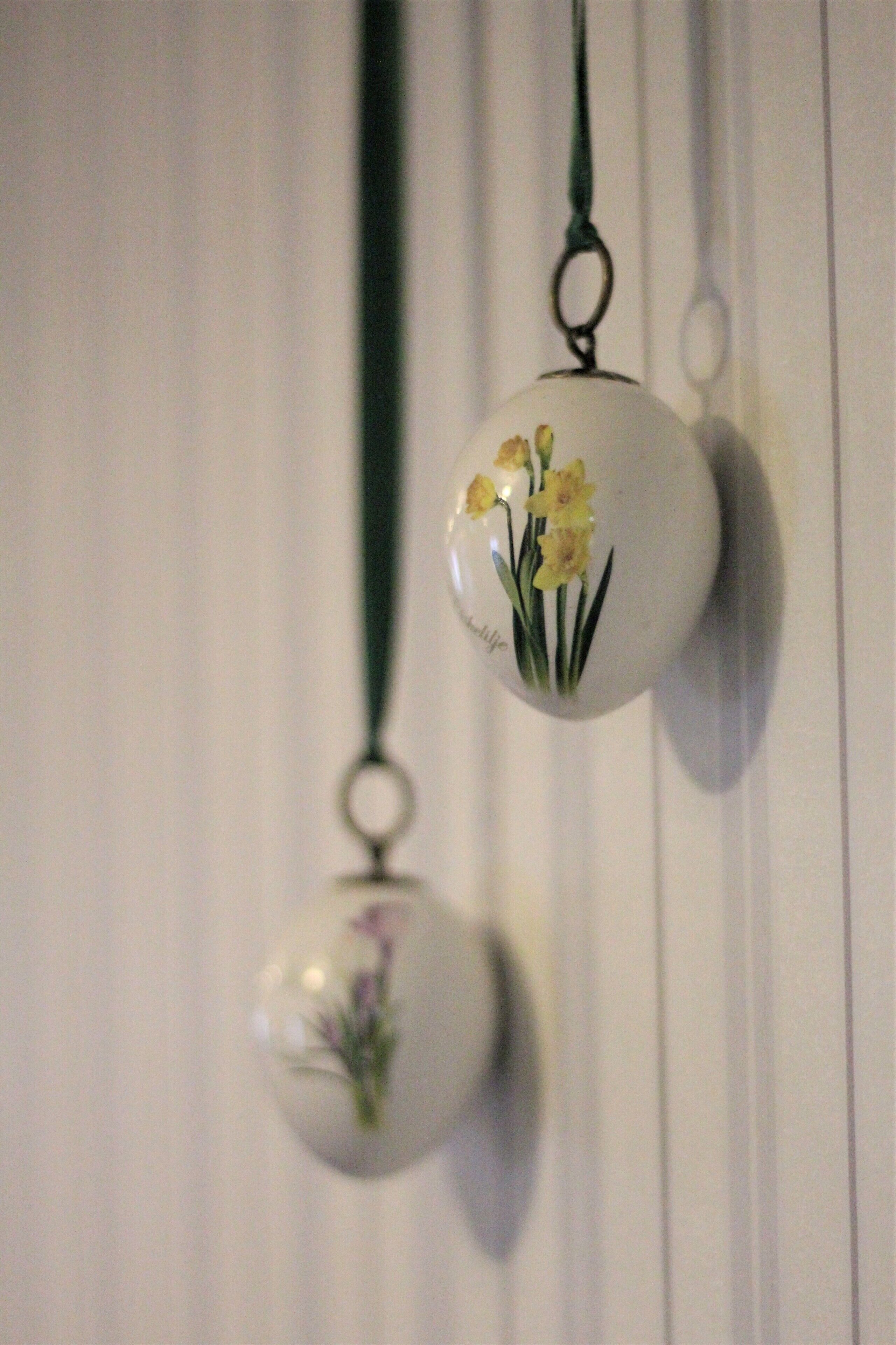 Dos adornos esféricos con motivos florales colgando de una pared.