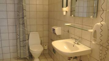 A bathroom with a toilet, sink, and shower curtain.