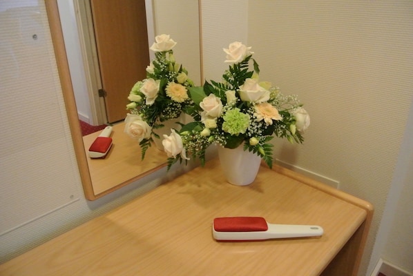 A bathroom with a wooden vanity, a mirror, and a bouquet of flowers on the counter. - Agerskov Kro og Hotel (Agerskov)