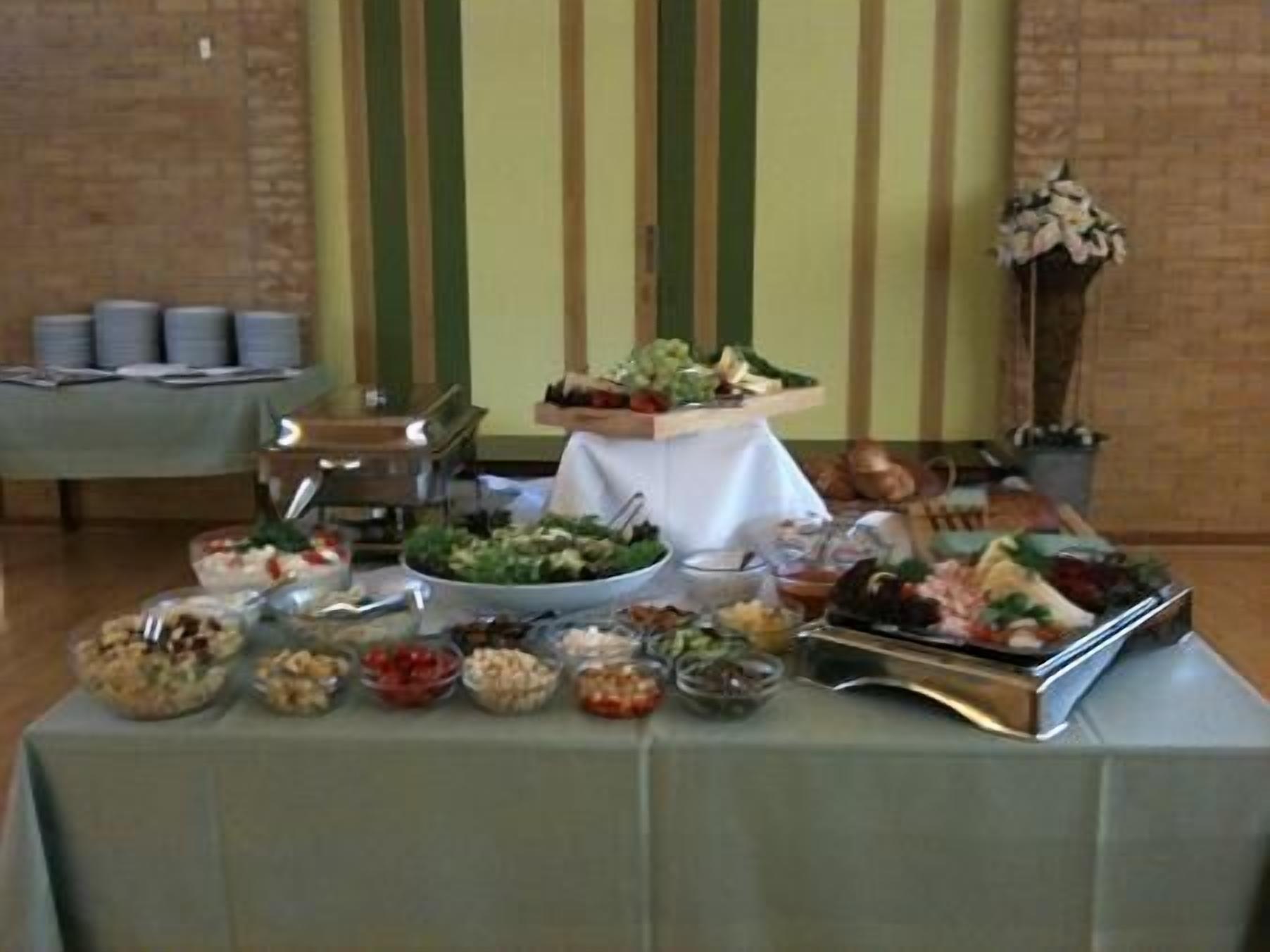 A buffet table with various food items and a decorative vase.