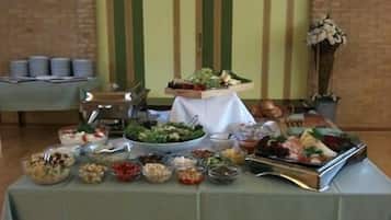 A buffet table with various food items and a decorative vase.