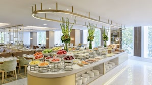 A buffet with various food items and a seating area with tables and chairs. - Royal Lancaster London (London)