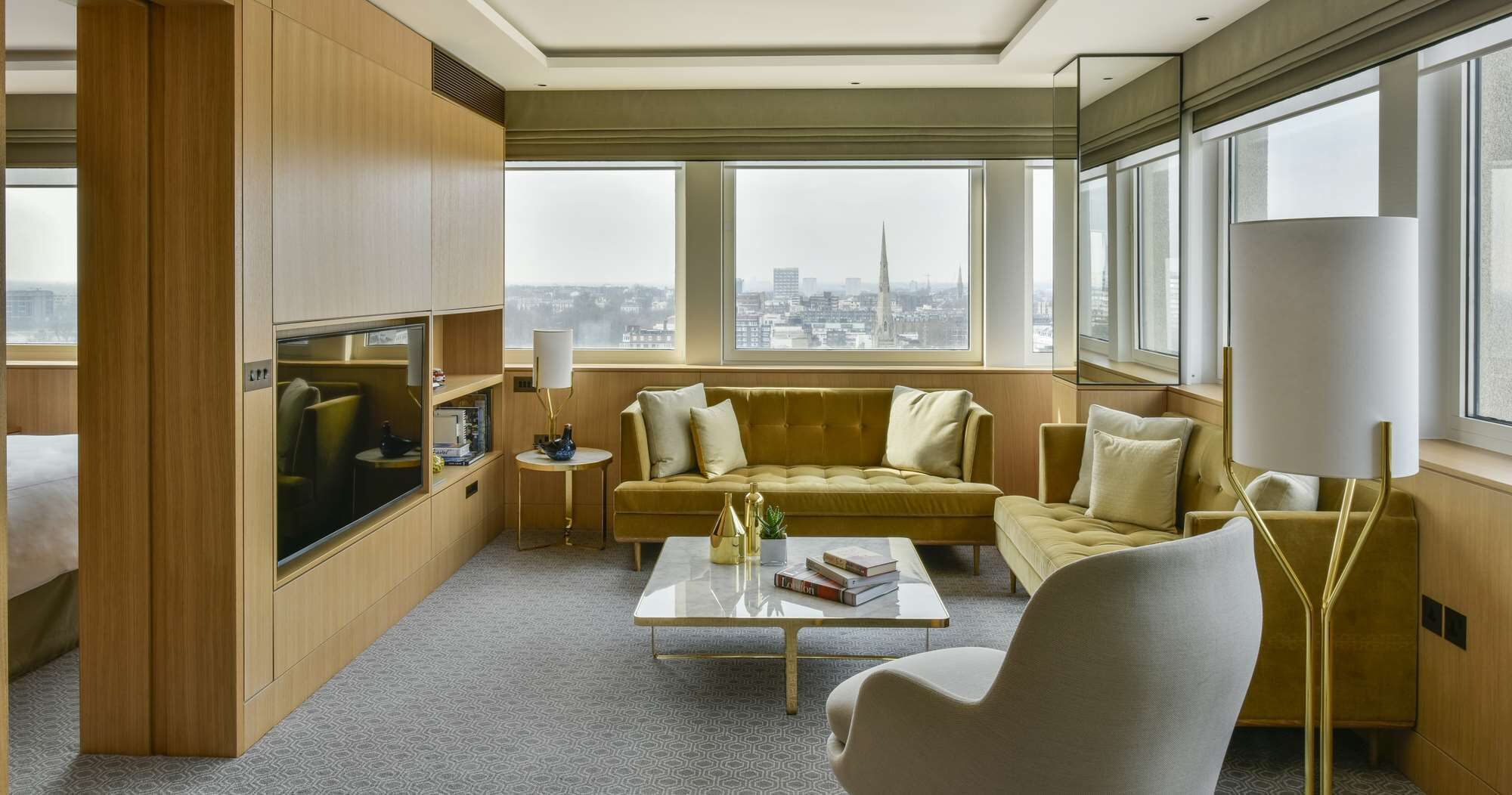 Una sala moderna con un sofá, una mesa de centro y un amplio ventanal con vistas a la ciudad.