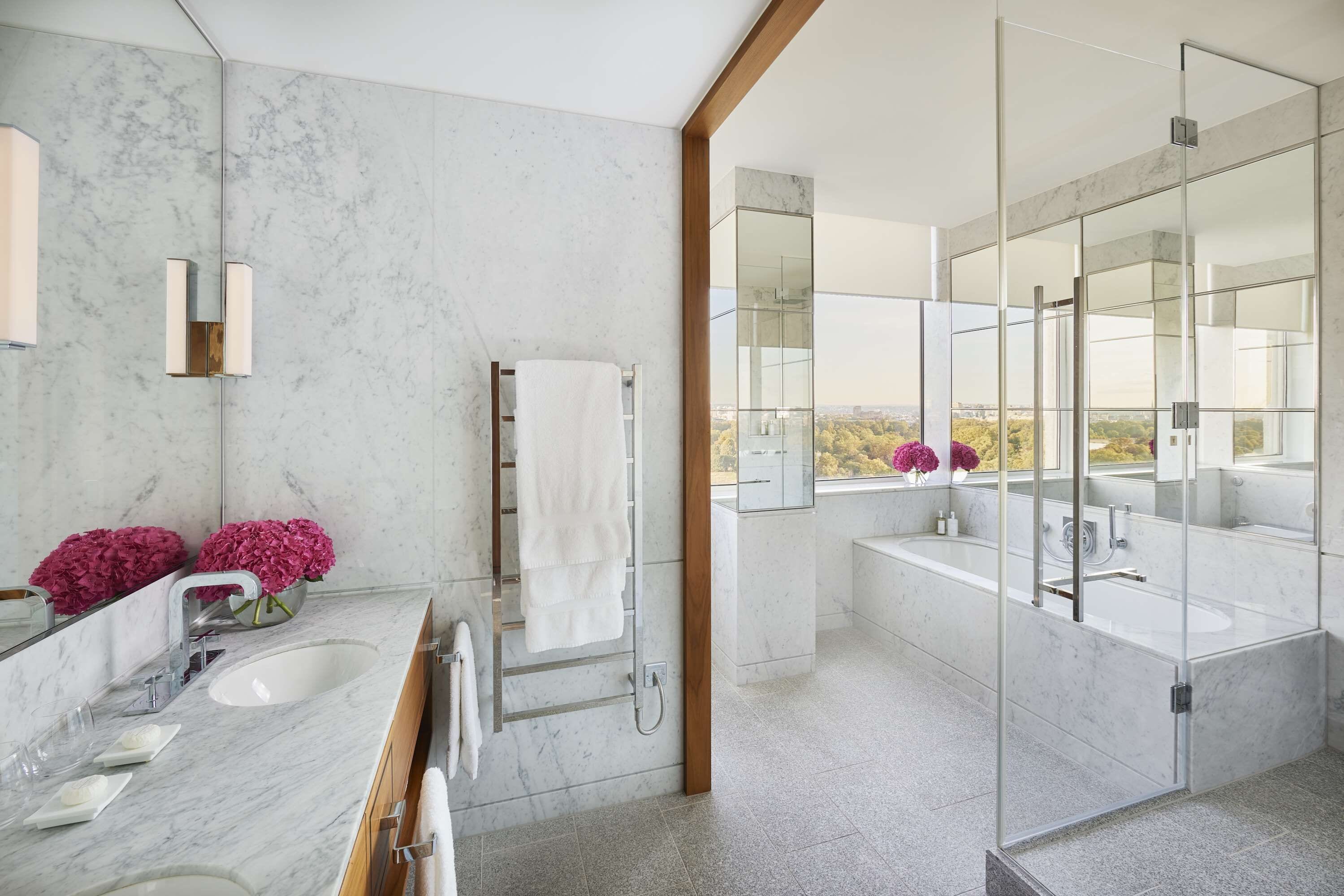 Une salle de bain moderne avec un grand miroir, un lavabo blanc et une baignoire.