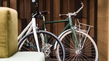 A bicycle parked next to a chair in a room with wooden paneling.