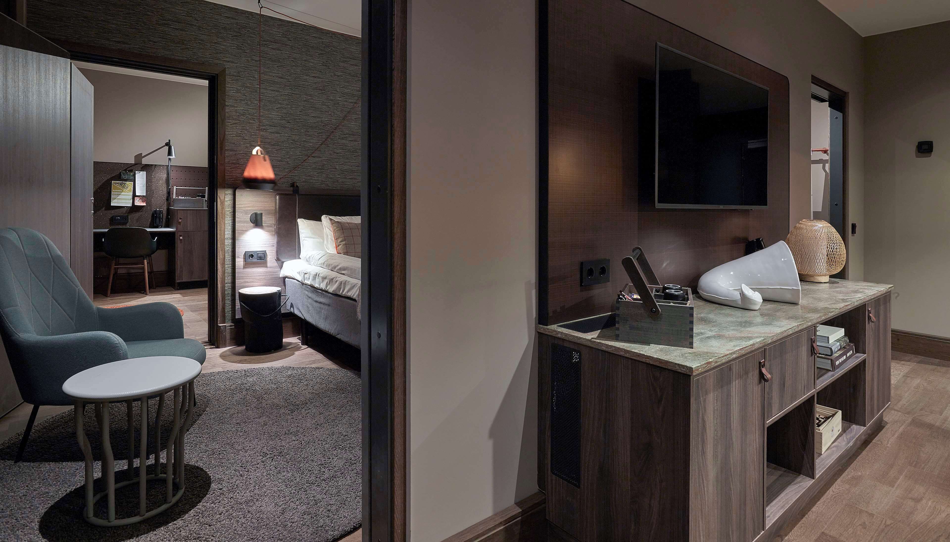 Une chambre d’hôtel moderne équipée d’un lit, d’un bureau, d’une chaise, d’une télévision et d’une petite table.