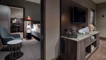 Une chambre d’hôtel moderne équipée d’un lit, d’un bureau, d’une chaise, d’une télévision et d’une petite table.