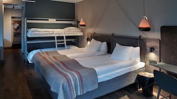 Una habitación de hotel moderna con una litera, una cama individual, un escritorio y una silla.