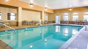 Une piscine dotée de chaises longues et d’un espace agrémenté d’un toit ouvrant.
