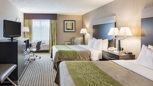 Une chambre d’hôtel avec deux lits, un bureau, une télévision, une chaise et une lampe.