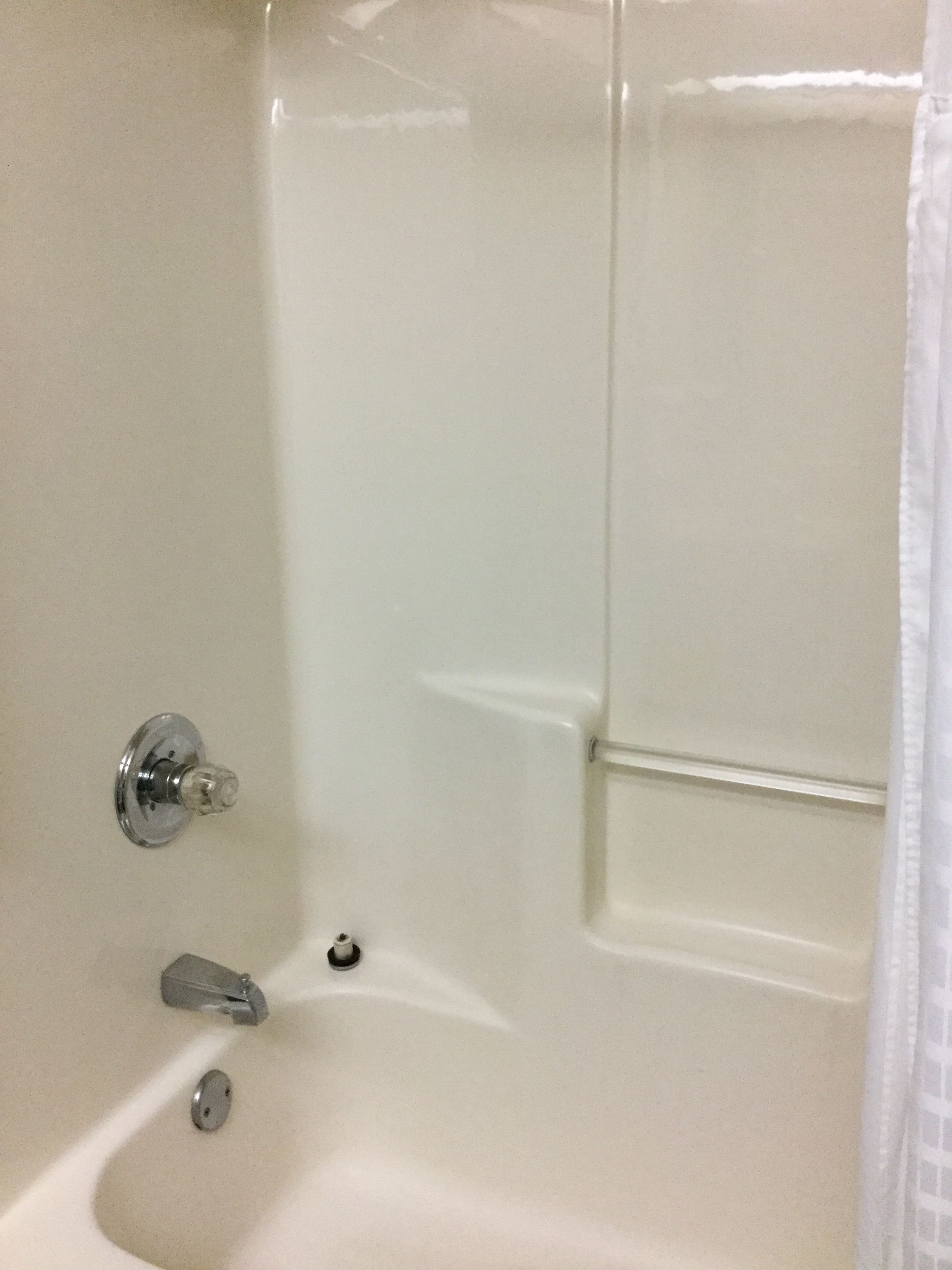 Une baignoire blanche avec un robinet chromé et une pomme de douche.